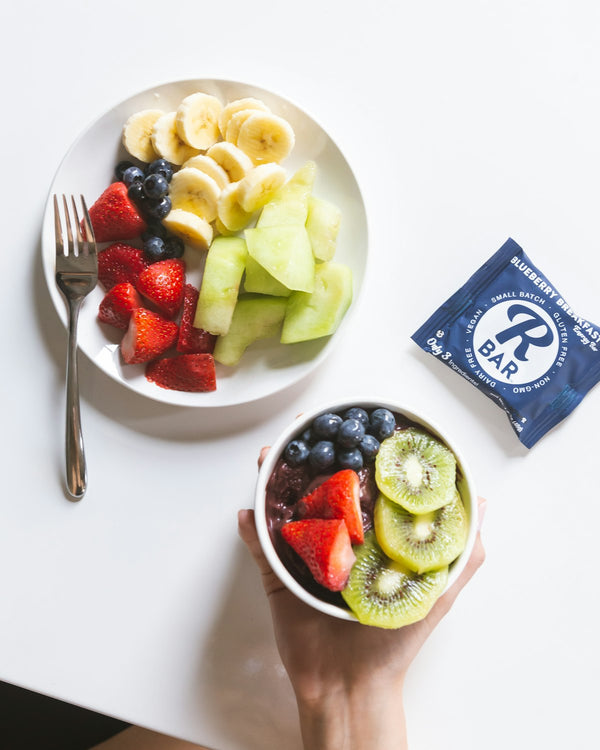 An overhead spread of fresh fruit including strawberries, banana, and kiwi