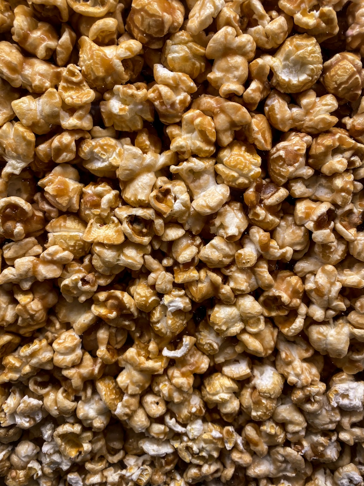 A pile of caramel popcorn with a sprinkle of sea salt
