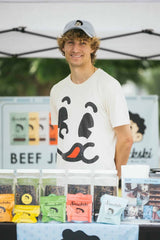 CJ, Snackski founder, at a farmers market booth